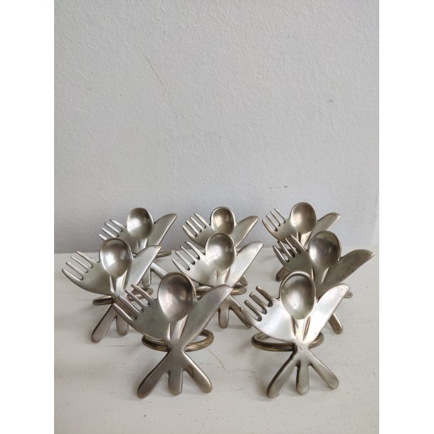 8 servietringe i metal med bestik, 1990'erne