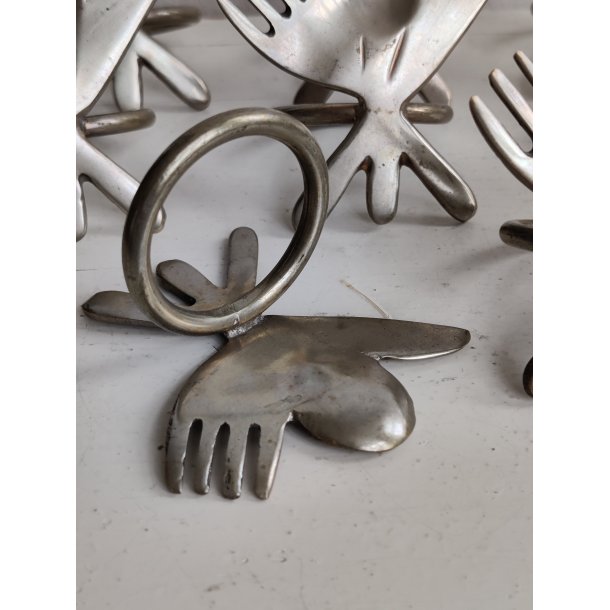 8 servietringe i metal med bestik, 1990'erne