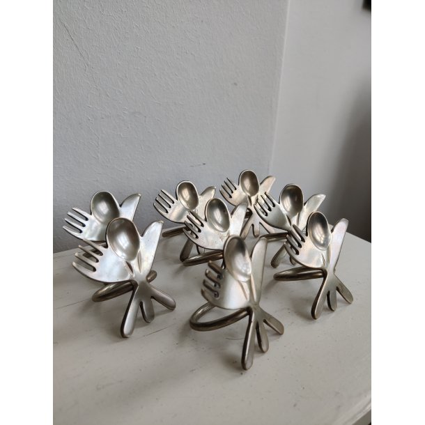 8 servietringe i metal med bestik, 1990'erne